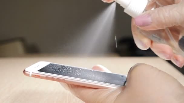 Desinfección telefónica contra virus y bacterias corona peligrosos. Primer plano de la mano femenina con guantes protectores usando toallita húmeda y desinfectante para limpiar la pantalla del teléfono celular. Las manos femeninas sosteniendo — Vídeos de Stock