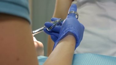 Female dentist applying anesthetic injection before oral treatment. injection to patient in dental clinic. Close-up shot of Dental cure. Medicine, dentist, and health care concept. 4k footage