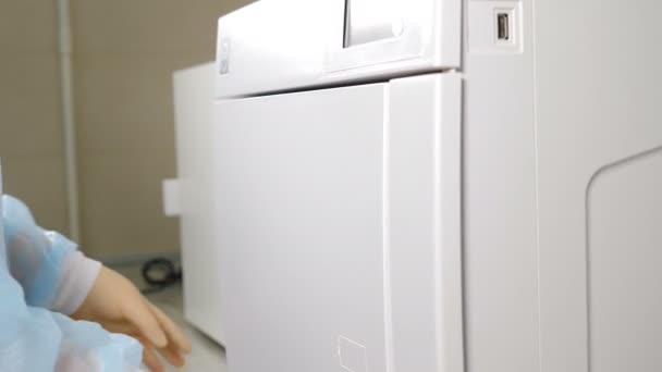 Odontología moderna. Asistente dentista femenina en guantes sacando bolsillos con instrumentos dentales esterilizados de autoclave. Limpieza, esterilización y desinfección de herramientas médicas en clínica dental — Vídeo de stock