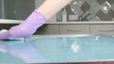 Antibakteriyel alkol peçetesiyle silme masası. Klinikteki yüzeylerin temizlenmesi ve dezenfekte edilmesi. Dezenfekte edilebilir ıslak mendiller. Tıbbi eldivenli eller beyaz silme yüzeyi. Önleme ve kontrol