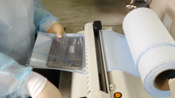 Викладання стоматологічних інструментів в пакет ремесел для подальшого дезінфекції в автоклаві. Стоматолог готує інструменти для стерилізації, стерилізація вбиває мікроорганізми. 4k кадрів. 4 k пострілів — стокове відео