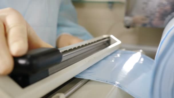 Wkładanie narzędzi dentystycznych do opakowania rzemiosła w celu dalszej dezynfekcji autoklawu. Dentysta przygotowuje przyrządy do sterylizacji, sterylizacji zabijania mikroorganizmów. Nagranie z 4 tysięcy. 4 tys. strzałów — Wideo stockowe