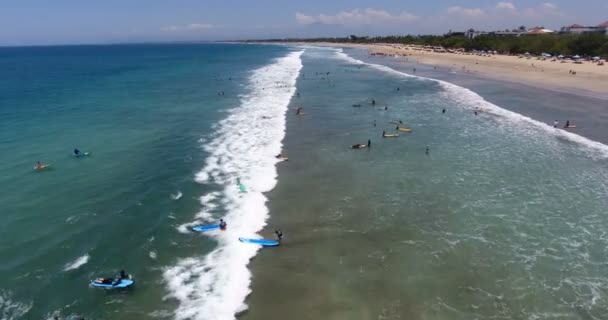 Время в пути. Успокойся, летние каникулы. Аэросъемка плавания людей с досками и серферов, ловящих и катающихся на волнах в океане, пляж Dreamland, Бали, Индонезия. концепция серфинга, 4 k видео — стоковое видео