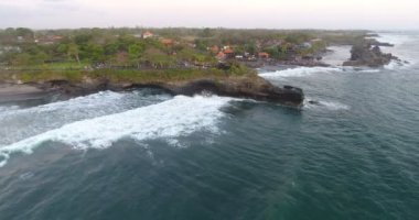 Bali kıyı şeridi kayalıkları. Bali 'nin güney kıyısı kayalıkları berrak gök mavisi okyanusla yıkanır. Dalgalar kayalara çarpıyor. İHA 'dan havadan çekilen görüntüler. 4k görüntü