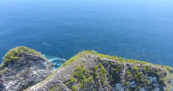 Flygfoto av drönare 4k kamera. Turkos hav med vågor och stenig klippa. På Bali. Indonesien. Zooma in skjuten. Stranden Dreamland, Bali, Indonesien. Restid. Slappna av, sommarlov. 4 k video — Stockvideo