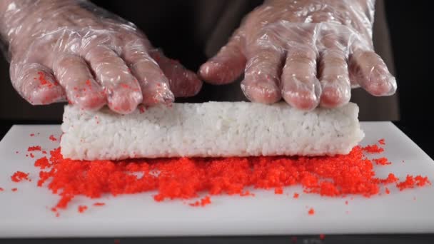 Cozinheiros Chef rola dragagem em caviar. Processo de fabricação de rolo de sushi. Vídeo de comida em câmara lenta. Comida asiática popular, Sushi no restaurante e para delievery. hd completo — Vídeo de Stock