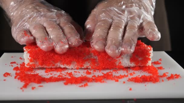 Populär asiatisk mat, sushi i restaurang och för delievery. Kock kockar rullar muddring i kaviar. Sushi rulla gör processen. Slow motion food-video. Fullständig hd — Stockvideo