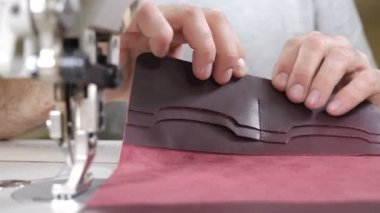 Erkek zanaatkar parmaklarıyla deri yapıştırıyor. Küçük özel giysi ve aksesuar imalatı. Moda ve terzilik konsepti. 4k görüntü