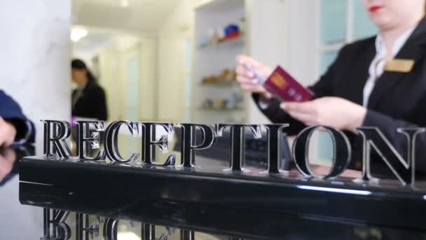 Direttore dell'hotel che dà la chiave della camera d'albergo alla reception, primo piano. Filmati offuscati. Chiave della camera d'albergo alla reception. Affari turistici, concetto di professione. 4K video — Video Stock