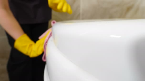 ホテルやアパートでの清掃。ホテルのスタッフからきれいなメイドは、ラグでシンクを洗浄します。住宅ビルの浴室で浴槽を拭く。ジャグジー掃除の女。四キロの映像 — ストック動画