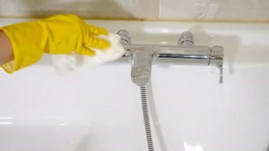 Ev yapımı banyo suyu musluğunu deterjan ve süngerle temizleme ya da mendille yakın çekim. Krom kaplama tuvaletler, bidonlar. Vinç ve kapı kollarını cilalamak. Otelde temizlik. 4 bin.