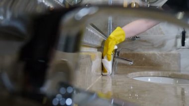 Ev yapımı banyo suyu musluğunu deterjan ve süngerle temizleme ya da mendille yakın çekim. Krom kaplama tuvaletler, bidonlar. Vinç ve kapı kollarını cilalamak. Otelde temizlik. 4 bin.