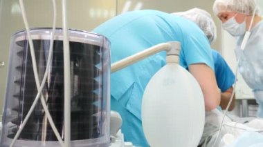 Tıp Merkezi Hastanesi vantilatörleri diş cerrahisinde nefes alıyor. Profesyonel diş cerrahlarından oluşan bir ekip genel anestezi ile hastaya invazif ameliyatlar yapıyor. 4k görüntü