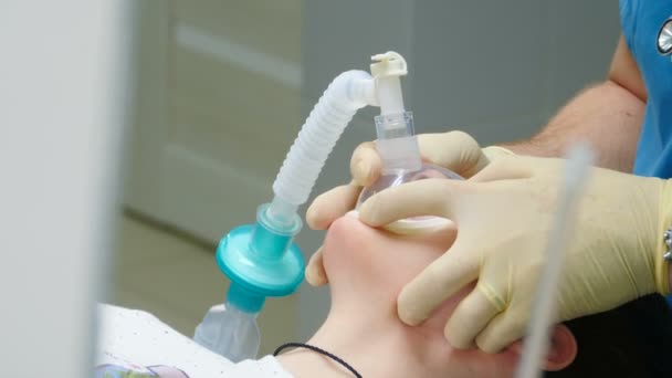 Operación quirúrgica siendo perfomada. operación en la clínica, paciente bajo anestesia con mascarilla facial, niño se quedó dormido en la silla de dentistas después de que le pusieron una máscara de oxígeno para realizar la odontología — Vídeos de Stock