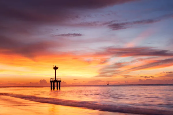 Deniz feneri ile plajda güneş battıktan sonra alacakaranlık — Stok fotoğraf