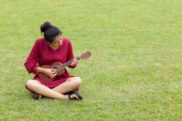 Vacker ung asiatisk kvinna spelar ukulee — Stockfoto