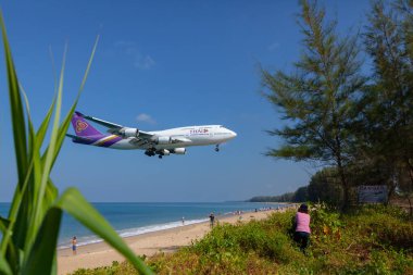 Phuket - Tayland; 19 Şubat 2019: Thai Havayolları Mai Khao plajı yakınlarındaki Phuket uluslararası havaalanına iniyor ve daha fazla insan uçakla fotoğraf çekmekten zevk alıyor.