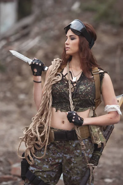 girl in uniform with weapons. a soldier in the war.