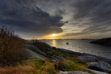 Setting sun sprinkling colors in the sky at  Saltholmen,Gothenburg sweden clipart