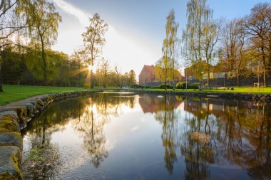 Göl evi ve ağaçlar ve güneş ışık yansıması ile.