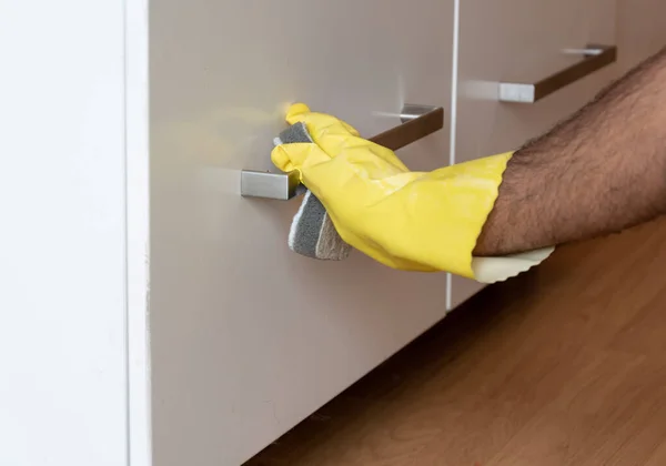 Cleaning kitchen cabinet with antibacterial spray to prevent spread of corona virus, COVID-19,Sweden