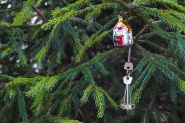 Noel ağacında Noel süsleri asılı yeni bir evin anahtarları. Açık havada..