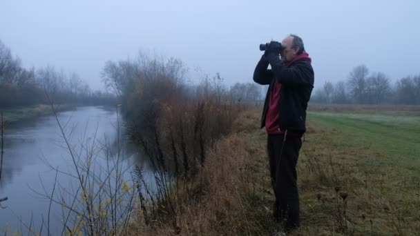 Atletische Man Zwarte Kleren Met Verrekijker Zijn Handen Loopt Door — Stockvideo