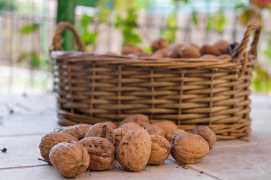 Bir masada ve hasır bir sepetin içinde izole edilmiş cevizler. Kırsal yaşam. Provence 'de açık havada. Sağlıklı Yeme.