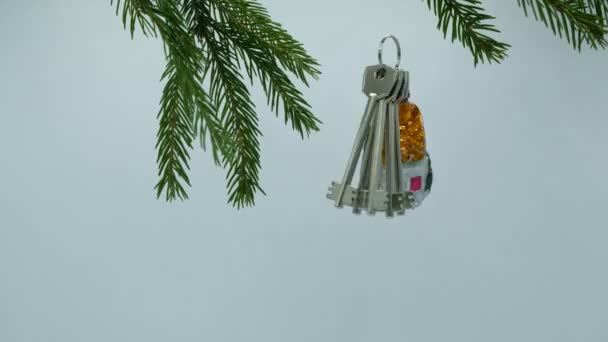 クリスマスプレゼントクリスマスの装飾が施された新しい家からの鍵は クリスマスツリーで白い背景に回転します — ストック動画