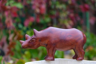 Kiraz yeşili arka planda kiraz rengi gergedan heykeli. Boşluğu kopyala.