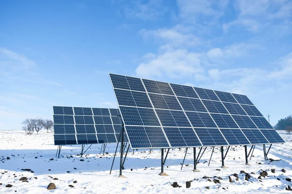 Güneş panelleri, Ukrayna 'da karlı bir tarlada güneşli bir kış sabahı. Kırsal kesimde yeşil enerji kavramı.