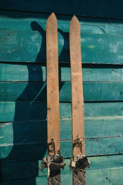 Ukrayna 'da güneşli bir günde, eladon yeşil renginin ahşap bir yüzeyinde ev yapımı akçaağaç kayakları. Eski teknoloji.