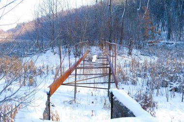  Karların altında sökülmüş bir köprünün paslı metal yapısı. Ukrayna 'da güneşli bir kış sabahı.