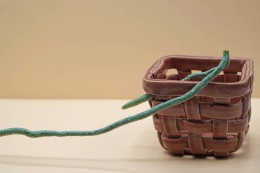 Pastel görüntü. Orkide kökü delikli alışılmadık bir seramik hasır sepet Dusty Rose Color. Saksı konsepti. Boşluğu kopyala.