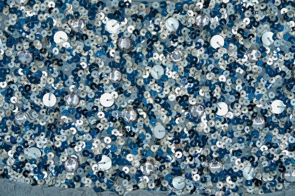 The surface of the paillettes. Blue, gray and white. Close up.