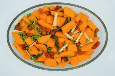 Pişirme kabında parlak sebzelerin karışımı. Taze balkabağı, kereviz, paprika, domates, yeşil bezelye, aromatik otlar, kuşkonmaz fasulyeleri izole edildi..