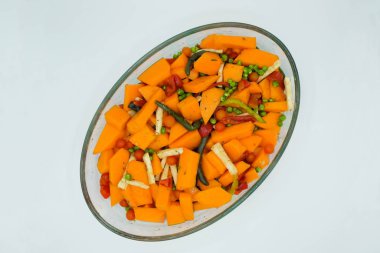 Pişirme kabında parlak sebzelerin karışımı. Taze balkabağı, kereviz, paprika, domates, yeşil bezelye, aromatik otlar, kuşkonmaz fasulyeleri izole edildi. Boşluğu kopyala.