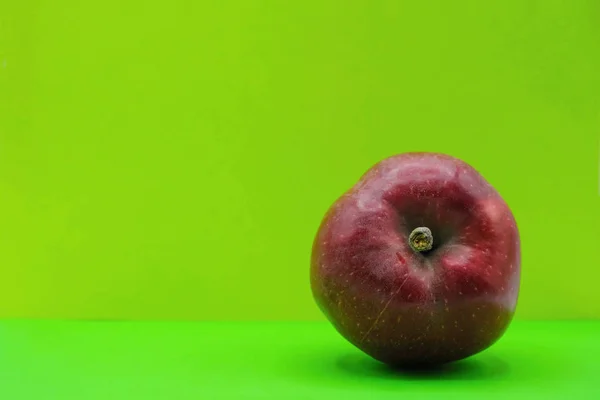 Red apple on neon green background in Ukraine. Health concept. Copy space. Minimalism.