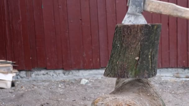 Een Man Snijdt Een Brandhout Met Een Bijl Een Dorp — Stockvideo