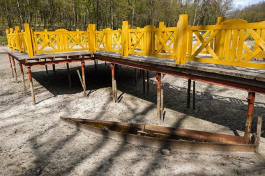 Ukrayna 'da kavrulmuş bir göl üzerinde köprü inşa etmek. Tahta ev yapımı su kalıntıları olan bir tekne. Çevre felaketi.