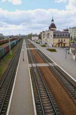 Lutsk Ukrayna 'daki tren istasyonu. Terk edilmiş bölge ve istasyon binası. Yük vagonları. Sabah sanayi manzarası. Üst Manzara. Dikey resim.