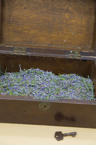 Brown vintage wooden chest with dried lavender flowers. The key near the chest. Copy space. Vertical image.