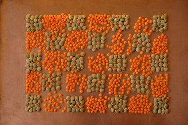 Bakır bir yüzeyde turuncu ve yeşil mercimek geometrik deseni.