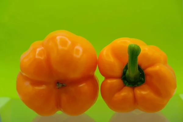 Elkülönített Két Narancspaprikát Egy Üvegfelületen Világoszöld Háttérrel Ukrajnában Közelről Fénymásolási — Stock Fotó