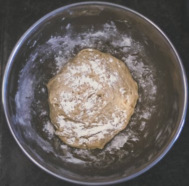 Mutfak tezgahına taze ev yapımı hamur bir parçasıdır. Hamur bir top haline döndürülür. Hamur ve sayaç üst çiçek ile serpilir.