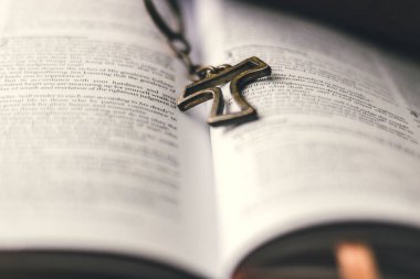 Kahverengi deri İncil açtı ve bir masanın üzerine koy. Ortasında açık Merkezi içi boş bir rustik kolye arıyorsunuz bağlama aittir. Gözlerimi bağlamayı Center'da ayarlama. 