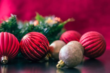 Kırmızı ve altın Noel top süsler onlar bir parlak siyah tablo yüzey Noel ağacına asılı için bekleyen oturuyorlar gibi bir yan açı fotoğrafı.