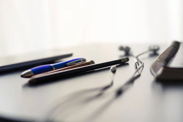 Office supplies are set on a shiny and reflective office desk. The objects on the desk signify the concept of old versus new technology. The interactive natural light and shadows create a simple yet compelling and contrasting image.