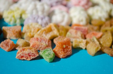 Çeşit çeşit fındık ve kurutulmuş meyve ve şekerli, mavi arka planda.