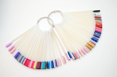 Beyaz uçlu ve arka planda jöle cilası olan farklı renklerin paleti. Oje için plastik testçiler
